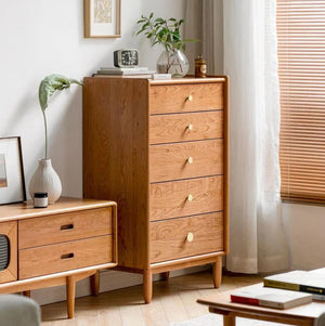 a living room with a wooden dresser next to a window