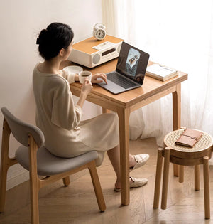 a woman sitting at a table with a laptop