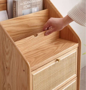 a person putting a book in a wooden drawer