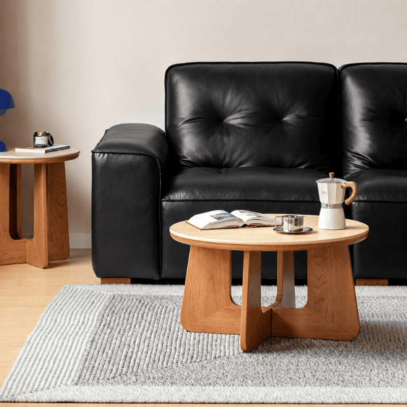 Anela Natural Solid Cherry Coffee Table with Travertine Top styled in a warm modern living room