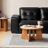 Anela Natural Solid Cherry Coffee Table with Travertine Top styled in a warm modern living room