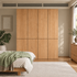Clovis natural solid oak modular wardrobe closed across bedroom wall