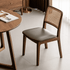 Natural solid walnut dining chair with cushioned leather pad and curved timber backrest