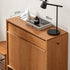 Enna natural solid cherry shoe cabinet styled with books, lamp and decor in a bedroom setting