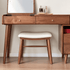 Graz walnut dressing stool with cream padded seat styled under a wooden dressing table