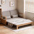 Natural oak convertible sofa bed with soft beige fabric upholstery and wooden armrests.