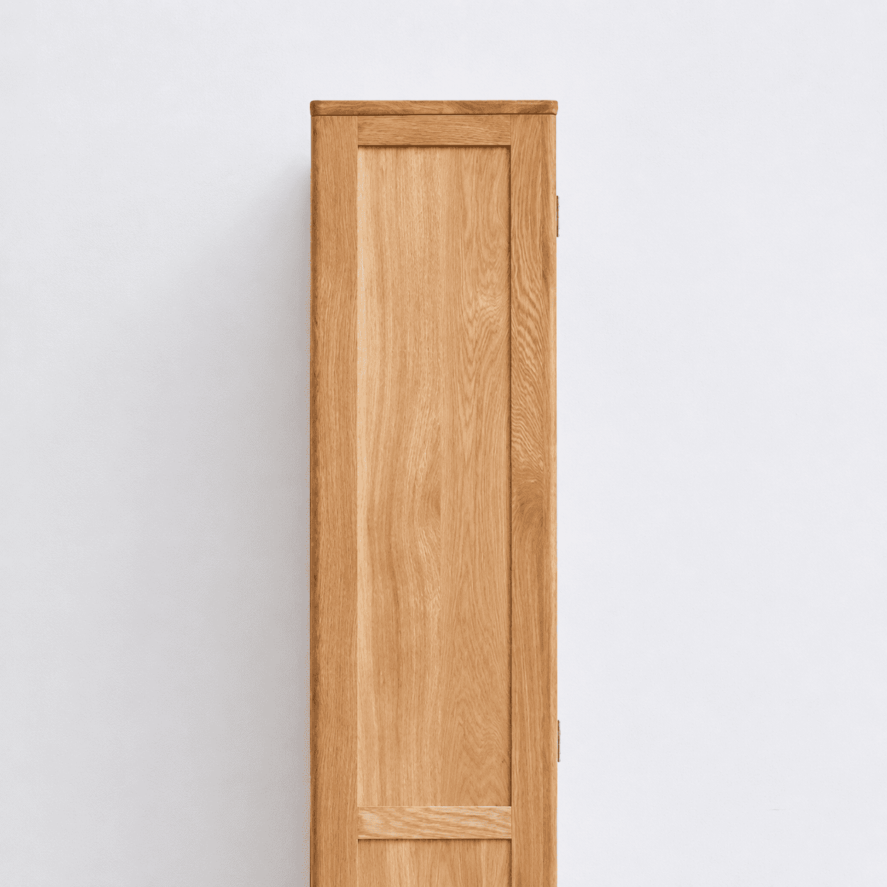 Side view of Humbie Solid Oak Slim Display Cabinet showing natural oak grain, solid wood panel and slim vertical design.