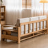 Natural oak sofa bed styled with matching pillows, side storage, and soft neutral décor