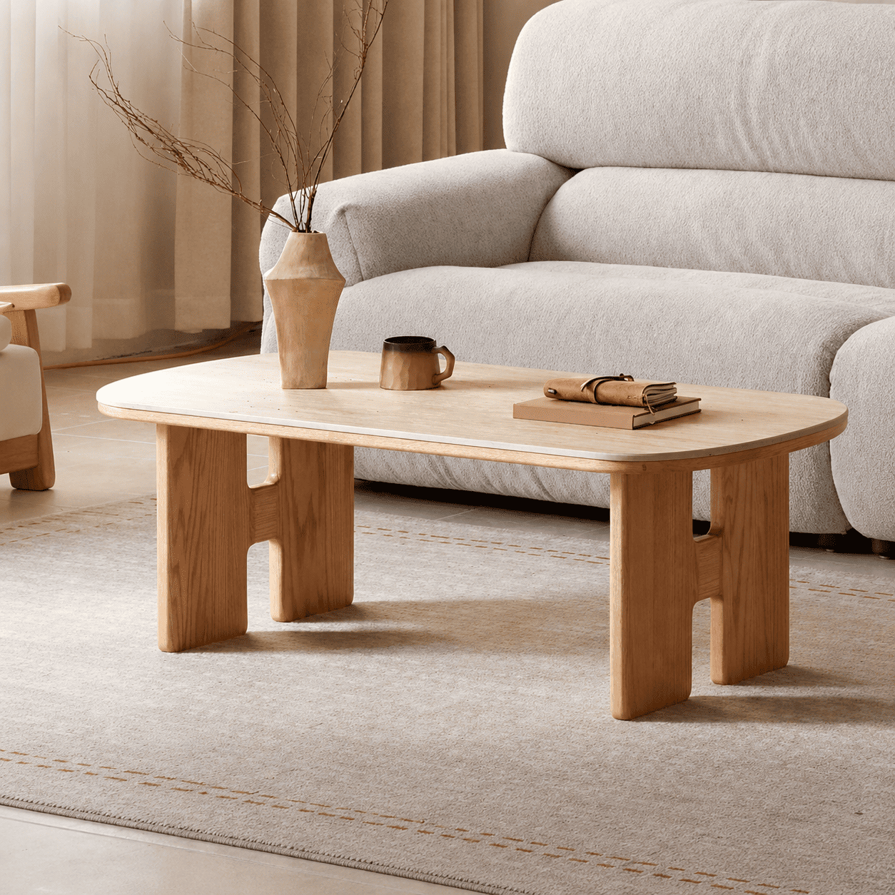 Irving natural solid oak coffee table with ceramic top styled in a warm neutral living room