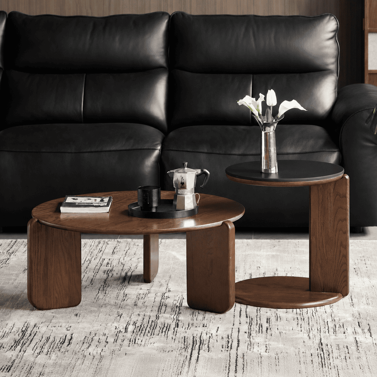 Jelling walnut-coloured solid oak coffee table set styled in front of a black leather sofa