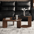 Jelling walnut-coloured solid oak coffee table set styled in front of a black leather sofa