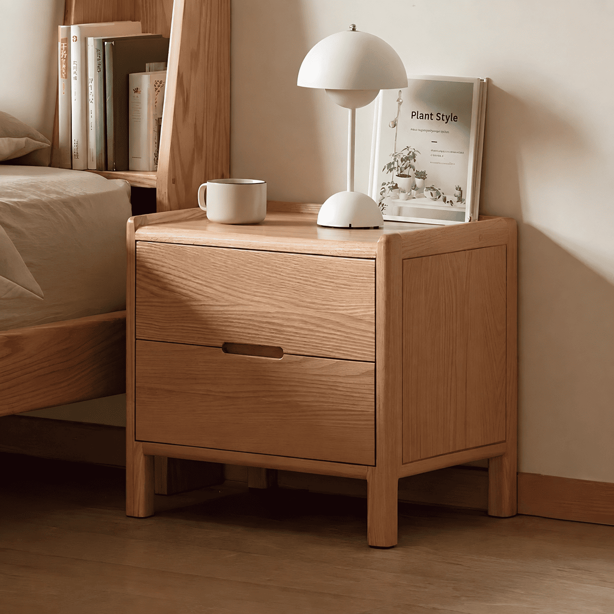 Kusel Natural Solid Oak Bedside Table with three drawers, raised edge top and warm oak grain beside a matching wooden bed.