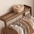 Close up of Lahti natural solid walnut coat rack top shelf and hanging rail with storage basket