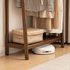 Close up of Lahti natural solid walnut coat rack lower shelf with woven storage box