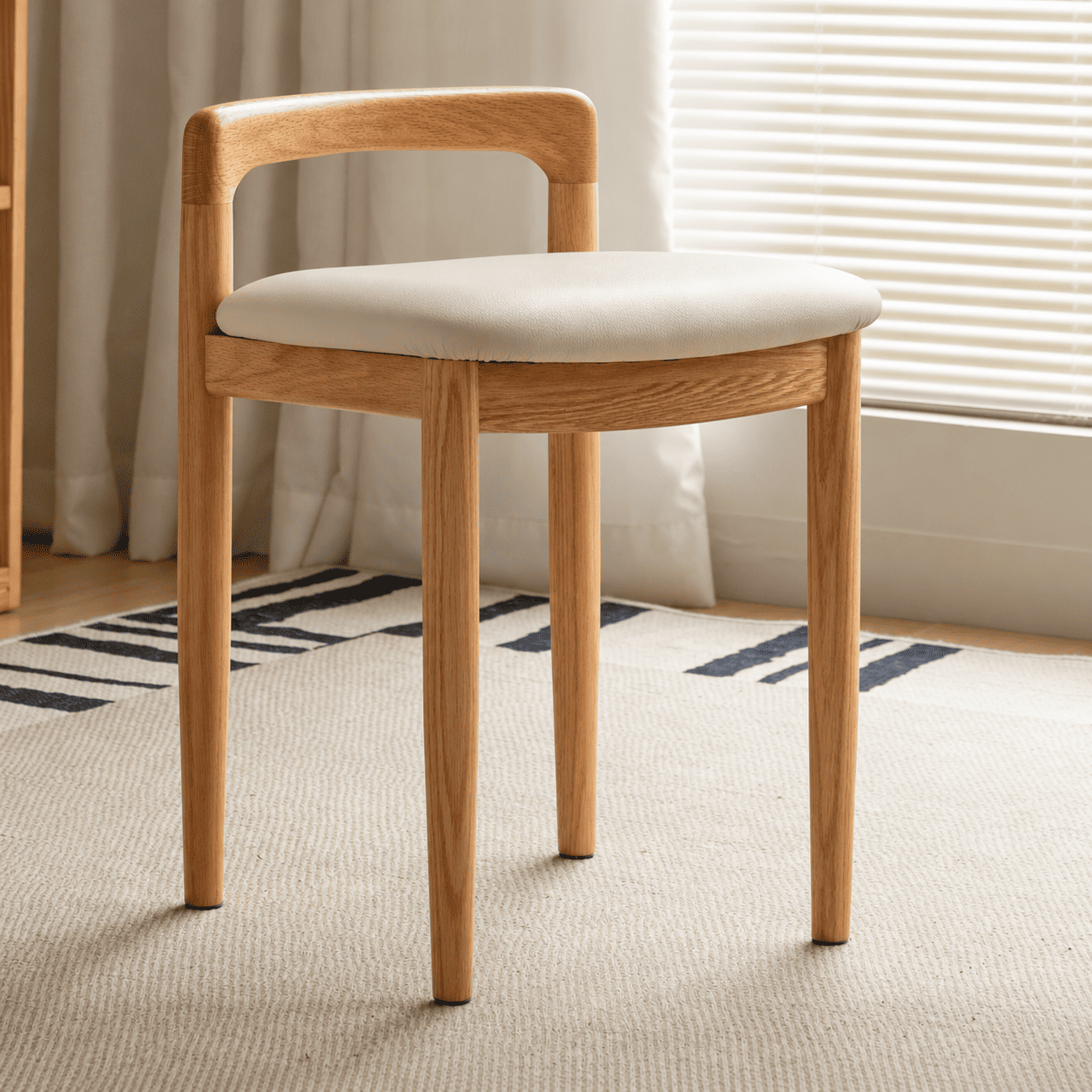 Nampa solid oak dressing stool with cream upholstered seat, curved backrest and tapered wooden legs
