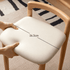 Close up of Nampa oak dressing stool cream cushioned seat and rounded solid wood backrest
