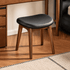 Norman natural solid walnut dressing stool with black upholstered seat styled under a wooden dressing table