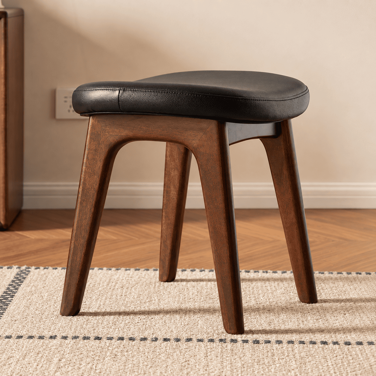 Norman solid walnut dressing stool with black cushioned seat and curved wooden frame
