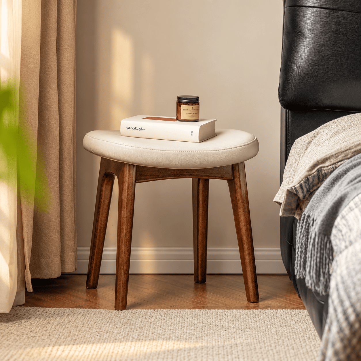 Norman walnut dressing stool with cream cushioned seat styled beside a bed and book