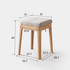 Scandinavian-style nesting stools in solid oak with soft fabric cushions and stackable storage.