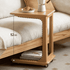 Compact wooden side table with wheels, open storage shelf, and minimalist design.