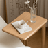 Mobile oak accent table with an open storage shelf for books and everyday essentials.