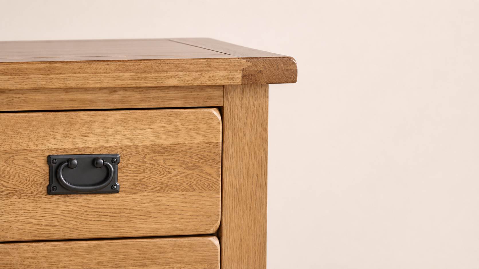 Close-up of the Rustic Country Rustic Oak Furniture Collection showing warm rustic oak grain, rounded drawer detail, and classic black metal handle.