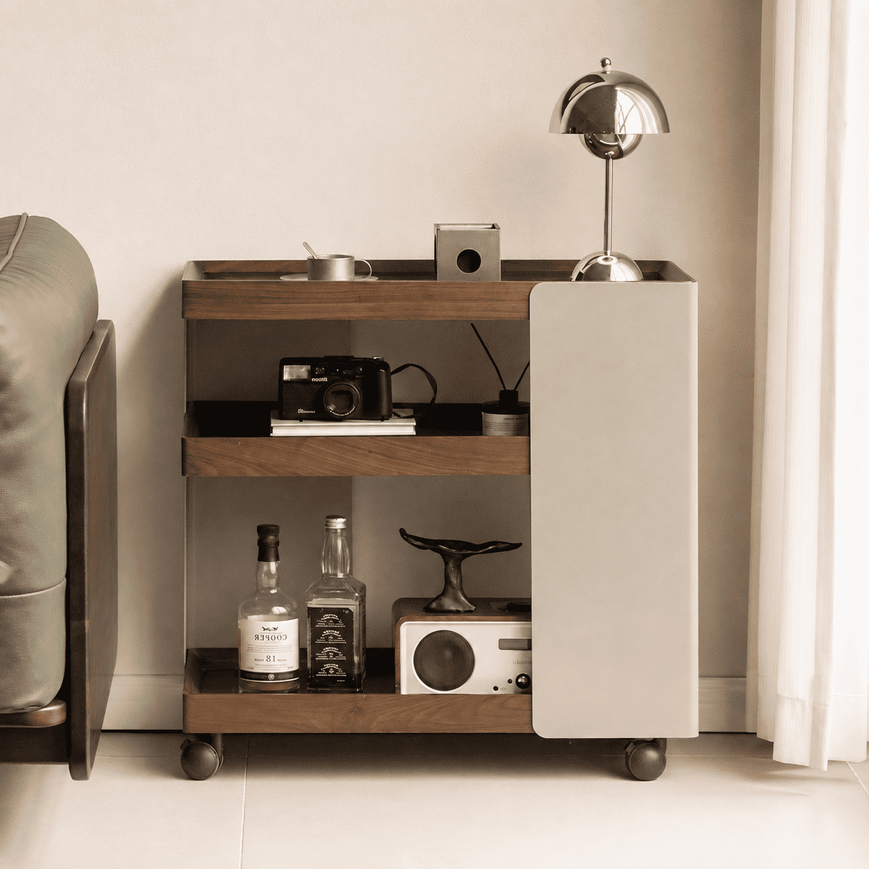 Front view of Toledo walnut movable side table styled beside a sofa with open storage shelves