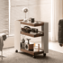 Toledo walnut movable side table beside sofa, styled with lamp, camera, books and decor