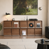 Walnut modular sideboard with sliding panels and metal rail details styled in a contemporary living room.