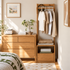 Compact solid oak coat rack with hanging rail, open shelf and storage drawer beside bedroom furniture