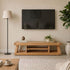 Solid oak entertainment unit paired with wall-mounted television, floor lamp, and indoor plants
