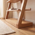 Solid oak small bookshelf styled with books, glass vases, sculptures, and wall art
